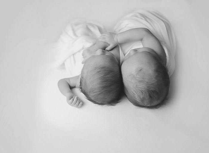 In-home newborn photography session in NYC with parents holding their baby