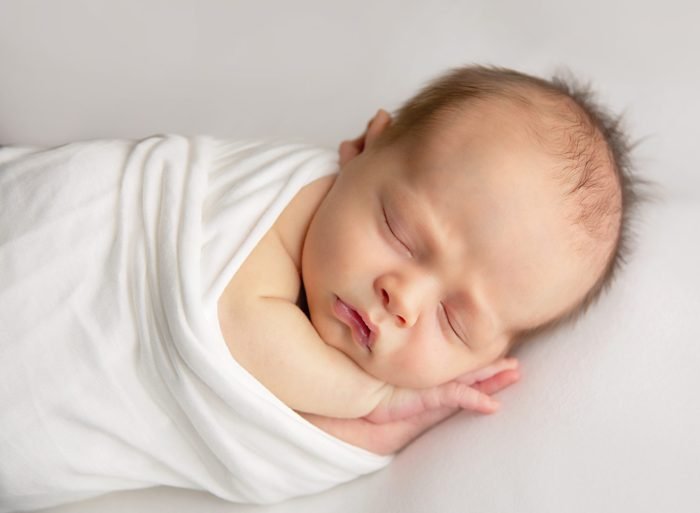 Grandparents holding newborn during an in-home newborn photography session in NYC