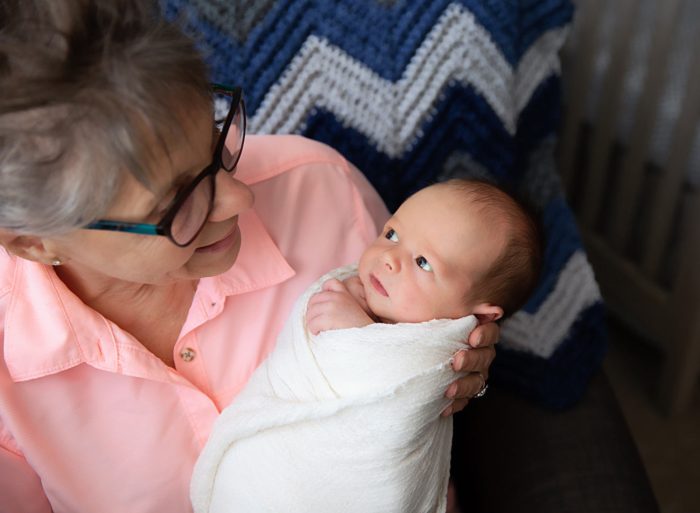 Grandmother meeting newborn baby during an NYC luxury in-home photography session