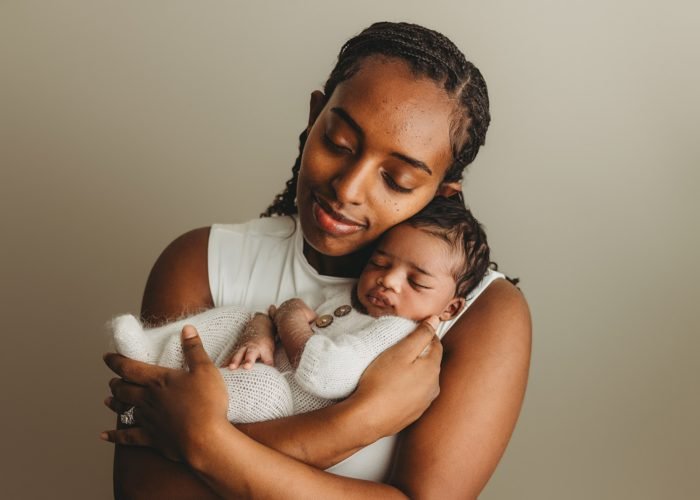 Mother cuddling newborn baby boy during Manhattan in-home newborn session