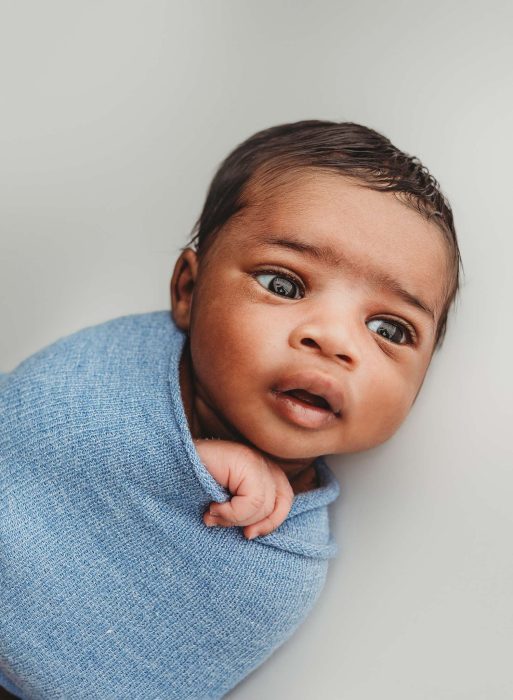 Newborn baby boy photographed with parents in a cozy Manhattan home