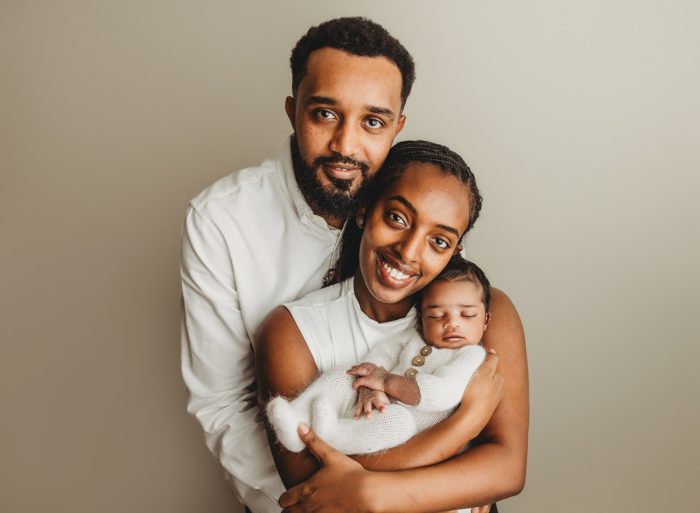 Parents snuggling newborn baby boy during New York City newborn session